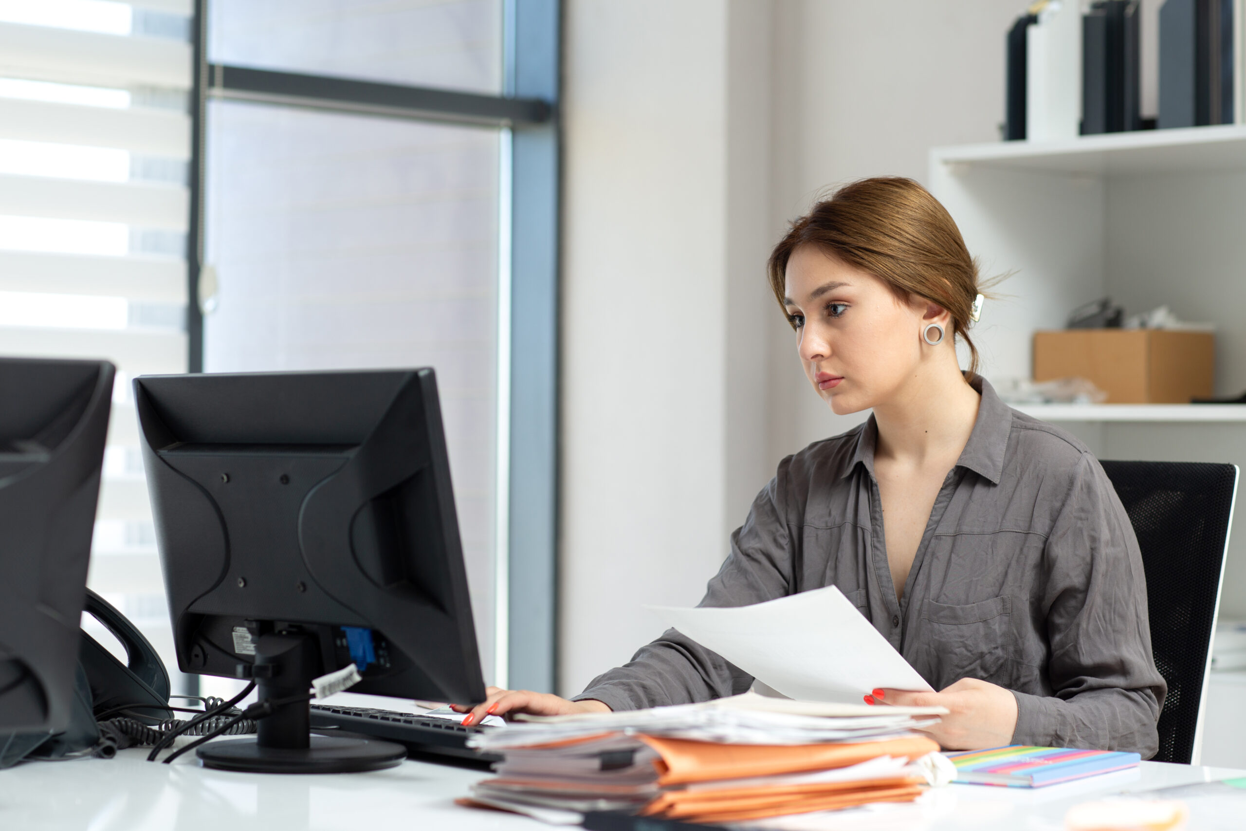 front view young beautiful lady grey shirt working with documents laptop sitting inside her office daytime building job activity